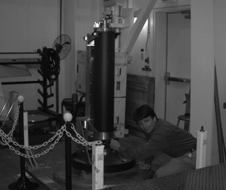 Image shows scientist kneeling in front of the boom predeployment