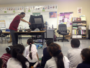 man in front of classroom with young students