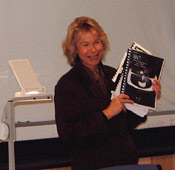 Janet Luhmann holding up some instructional material, facing the class.