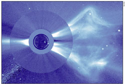A dark small circle is at the left, enclosed by a slightly larger light circle, whichi is itself enclosed by another larger blue disk. The disk shoots out wind-like material to the right.